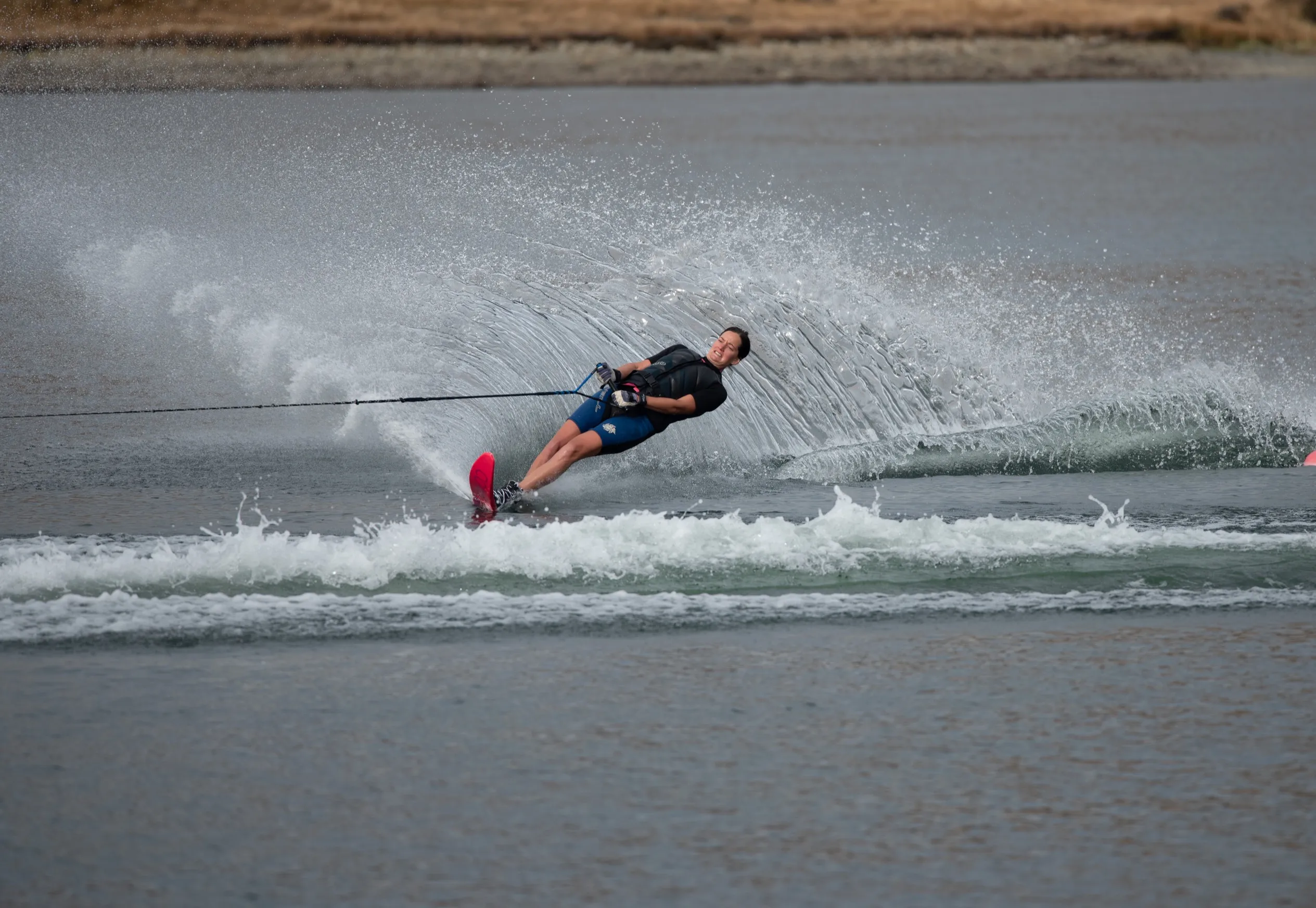 A club skier carving a slalom turn and throwing a wall of spray on Lake Clearwater